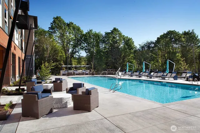 a view of a swimming pool with couches and lounge chairs