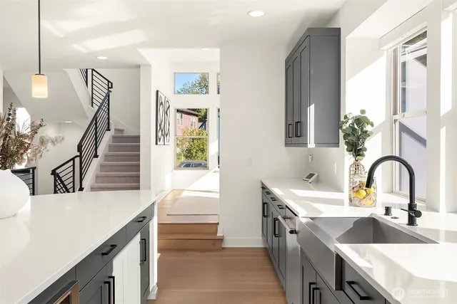 a kitchen with a sink and a stove with wooden floor