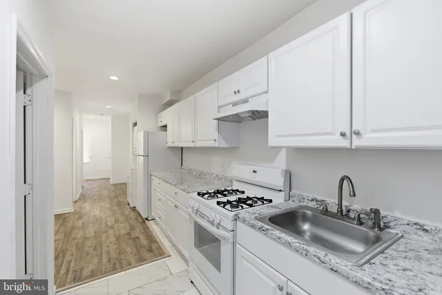 a kitchen with white cabinets and appliances