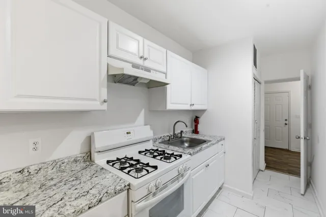 a kitchen with white cabinets and appliances