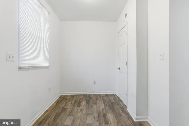 a view of a small space with wooden floor and a window
