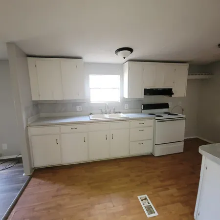 a kitchen with granite countertop a sink cabinets and stainless steel appliances
