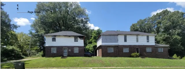 a view of a house with a yard and a large tree