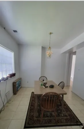 a view of a house with a yard and a large tree