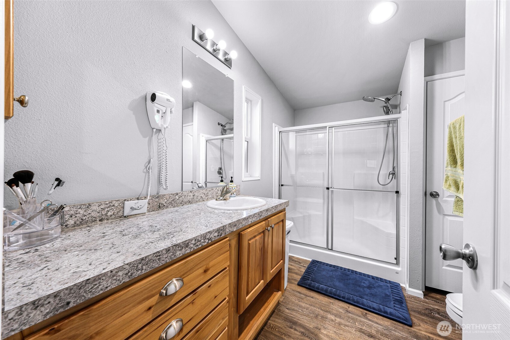 2392 Douglas Road, Unit 57 Ferndale, WA 98248 - Photo 20 of 26 a bathroom with a granite countertop sink a mirror and a shower