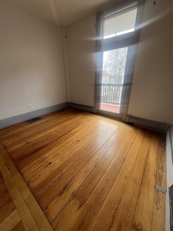 4 Herbert Street, Unit 2 Boston, MA 02124 - Photo 2 of 12 an empty room with wooden floor and windows