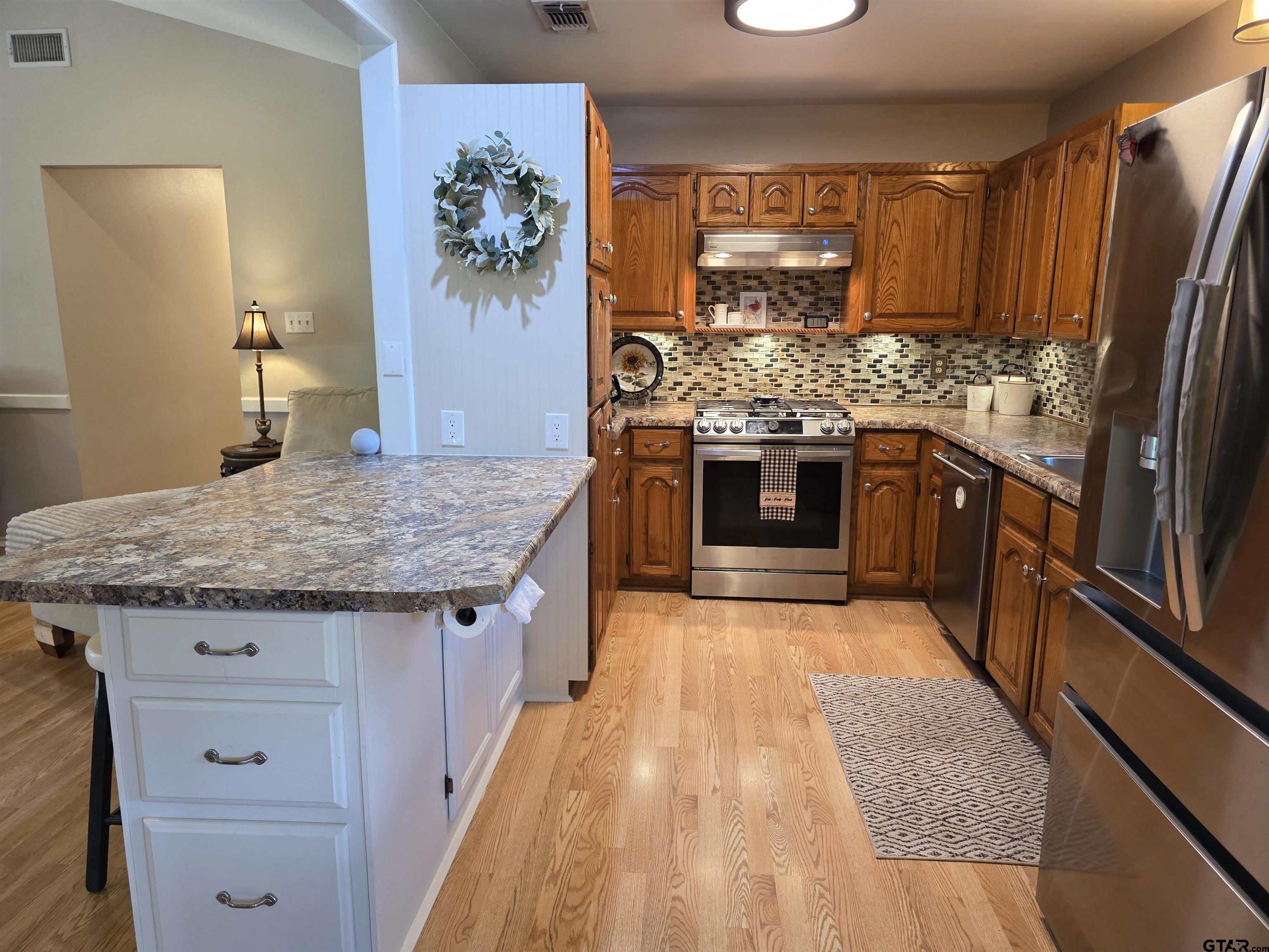 6170 Highway 271 Mount Pleasant, TX 75455 - Photo 15 of 43 a kitchen with stainless steel appliances granite countertop a stove and cabinets