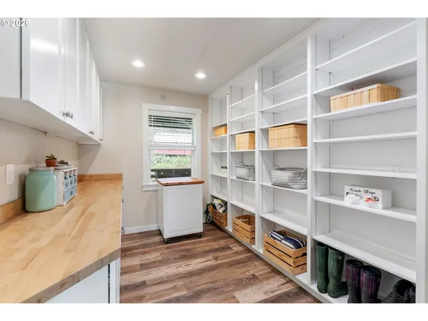 a kitchen with stainless steel appliances wooden floor and view living room