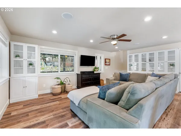 a living room with furniture a ceiling fan and a flat screen tv