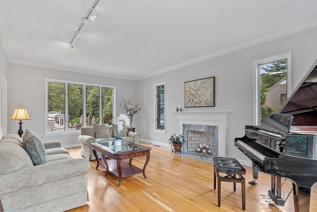 7 Powers Road Andover, MA 01810 - Photo 11 of 42 a living room with furniture a fireplace and a flat screen tv