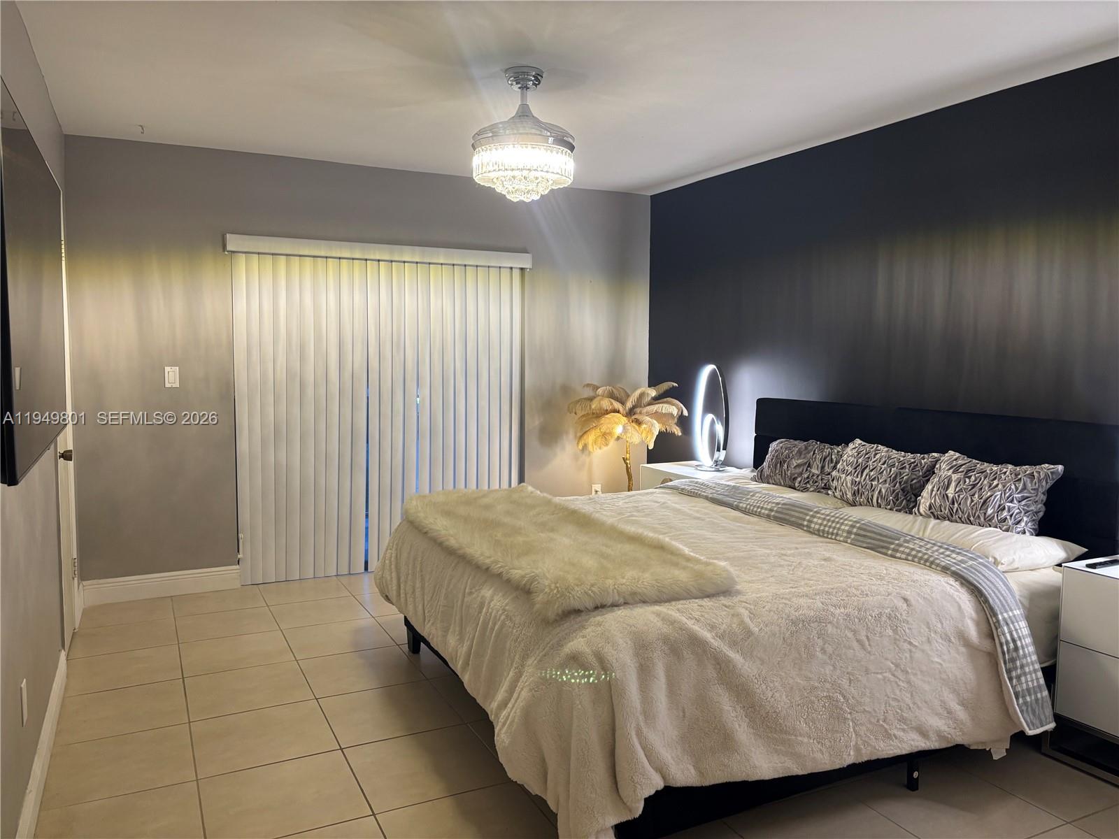 8384 Southwest 154th Avenue, Unit 68 Miami, FL 33193 - Photo 21 of 47 a bedroom with a bed and a chandelier
