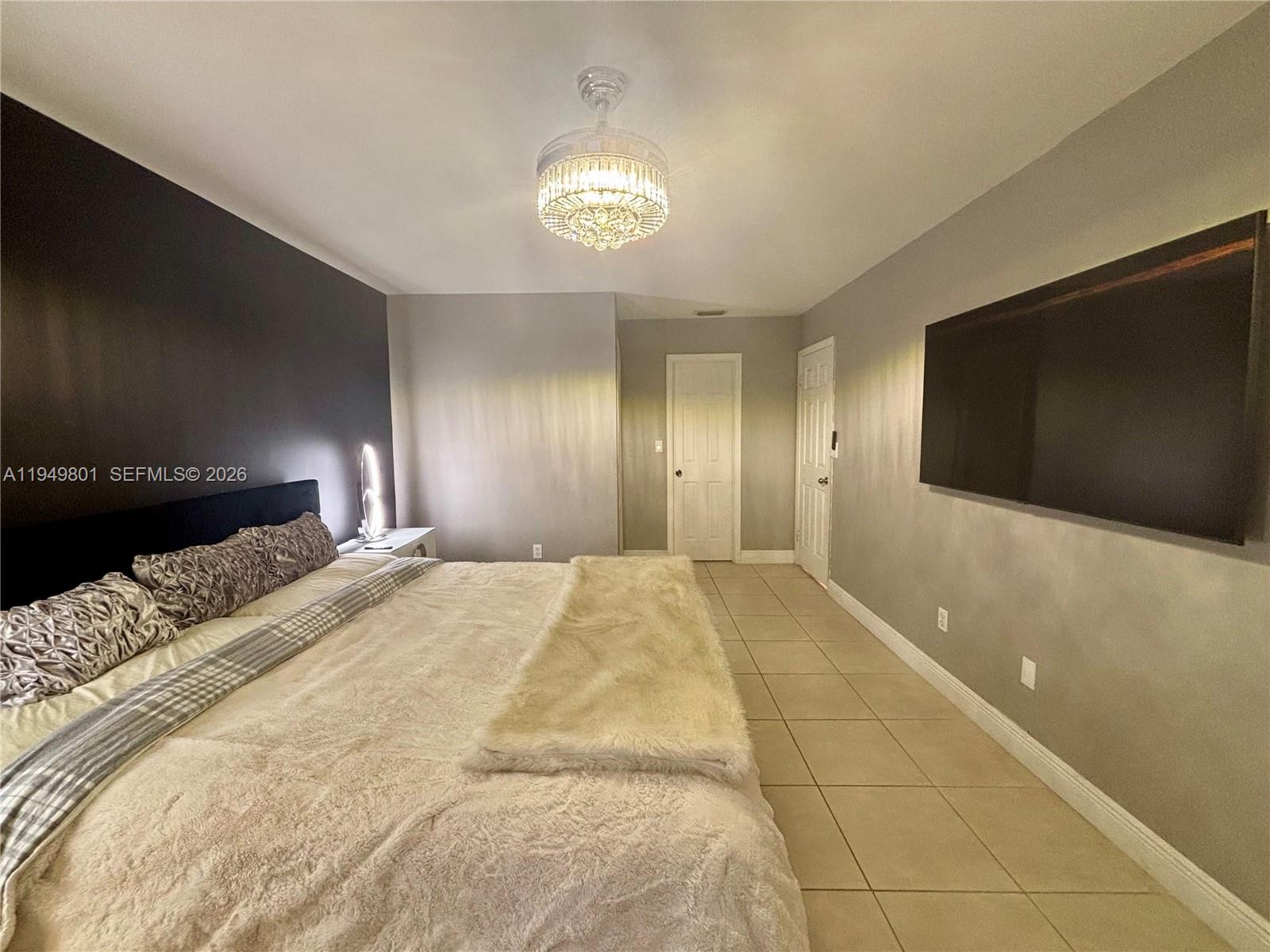 8384 Southwest 154th Avenue, Unit 68 Miami, FL 33193 - Photo 26 of 47 a spacious bedroom with a bed and a flat screen tv