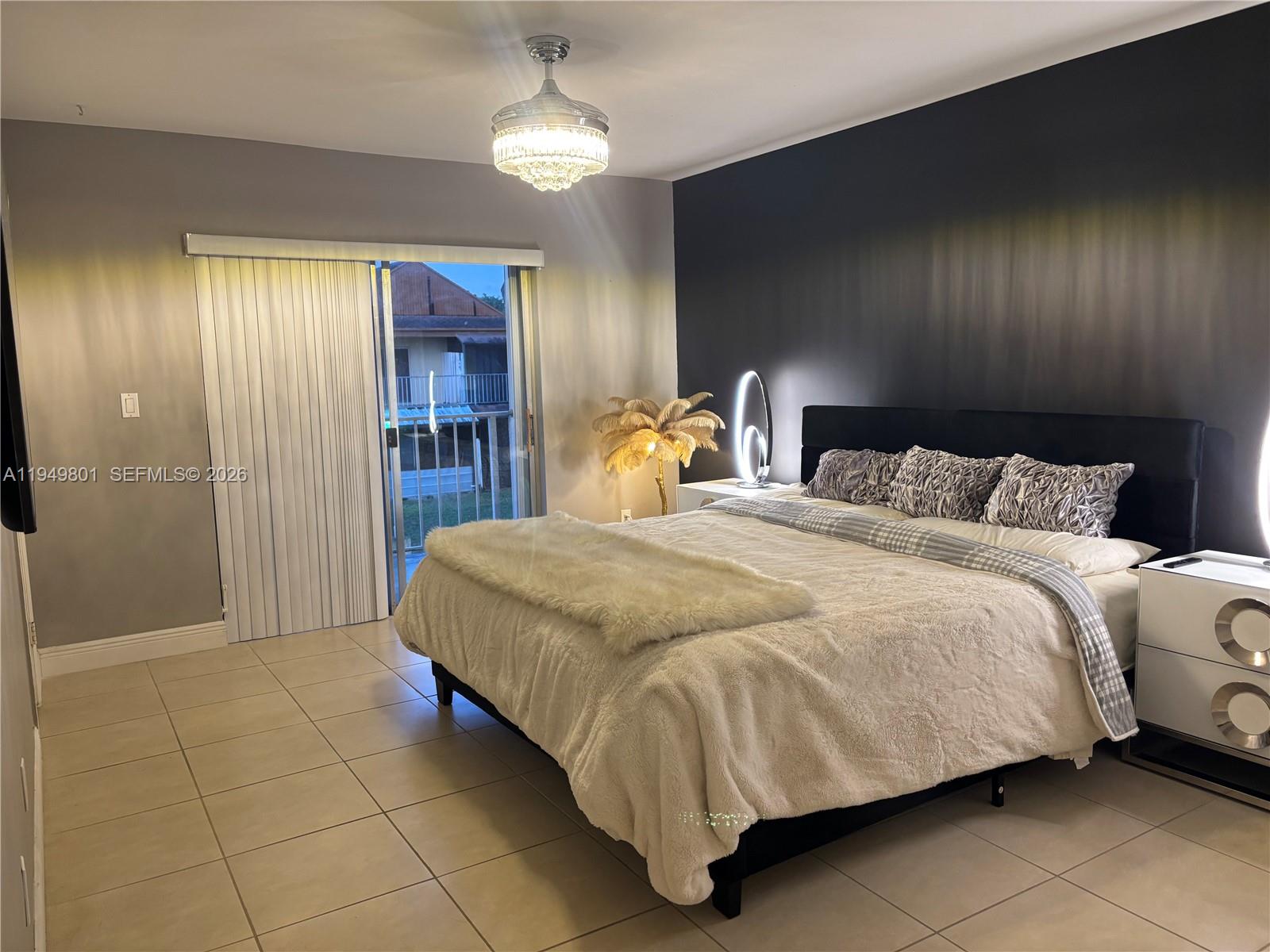 8384 Southwest 154th Avenue, Unit 68 Miami, FL 33193 - Photo 28 of 47 a bedroom with a bed and a chandelier