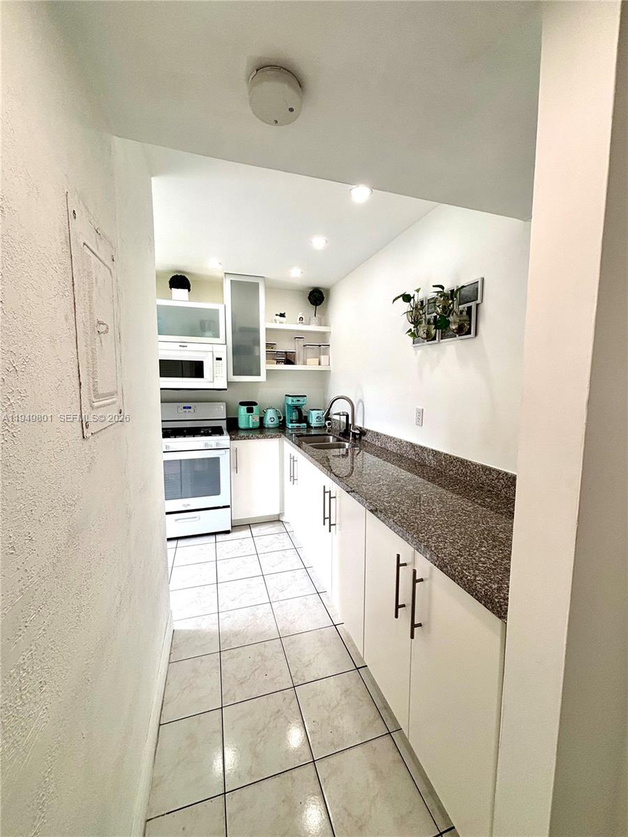 8384 Southwest 154th Avenue, Unit 68 Miami, FL 33193 - Photo 46 of 47 a large white kitchen with a stove a refrigerator a sink and dishwasher