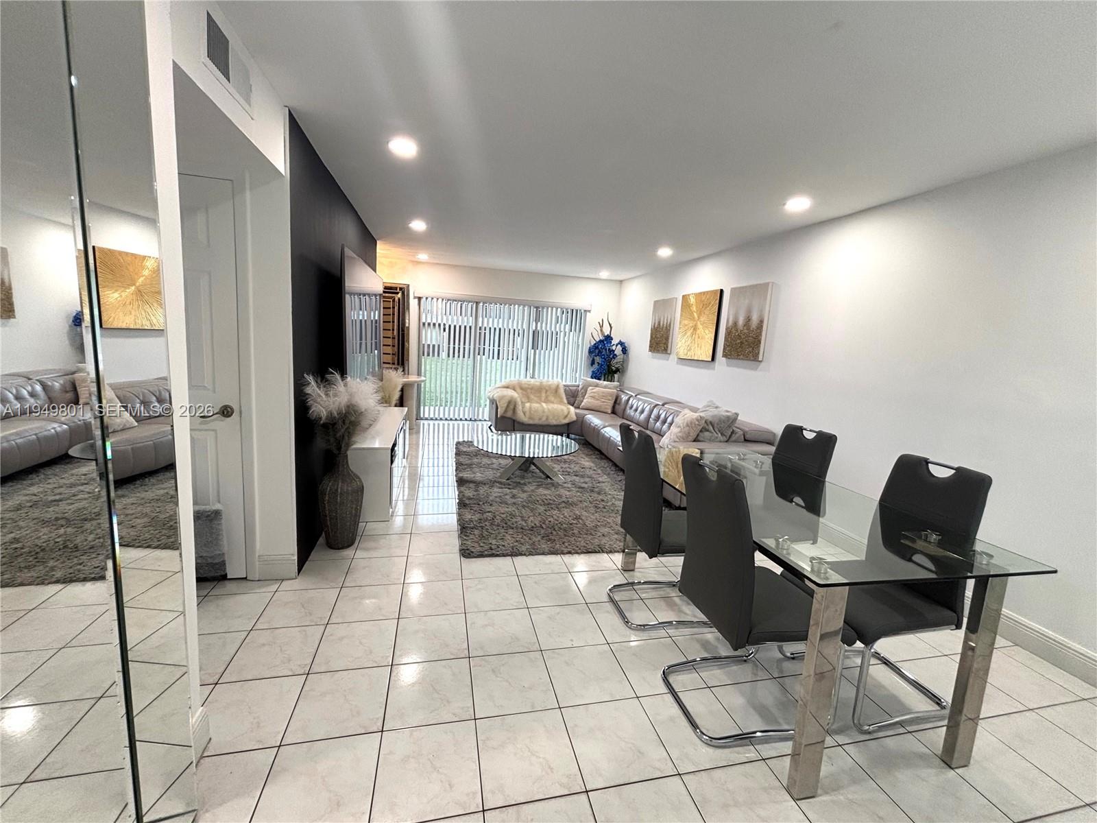 8384 Southwest 154th Avenue, Unit 68 Miami, FL 33193 - Photo 6 of 47 a living room with couches and kitchen view with wooden floor