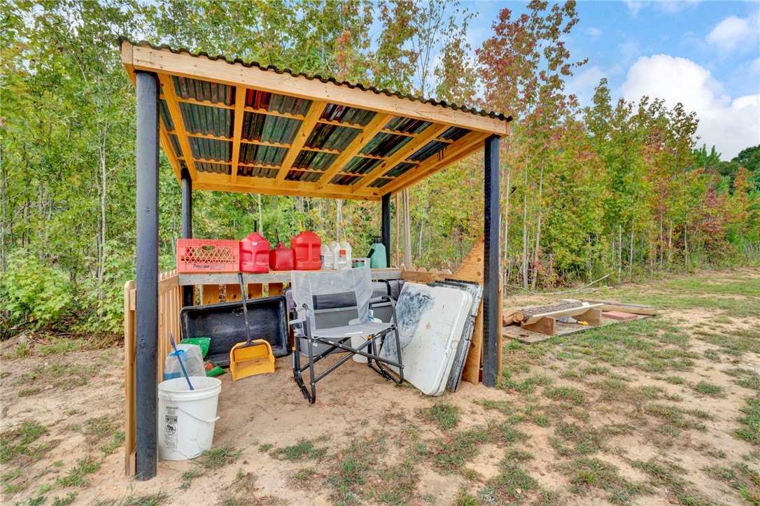 2655 State Rd S-4-108 Anderson, SC 29624 - Photo 33 of 37 A covered outdoor structure offers practical utility space on a wooded lot.