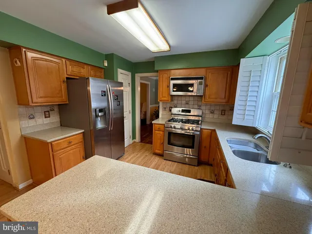 a kitchen with stainless steel appliances a refrigerator sink and stove
