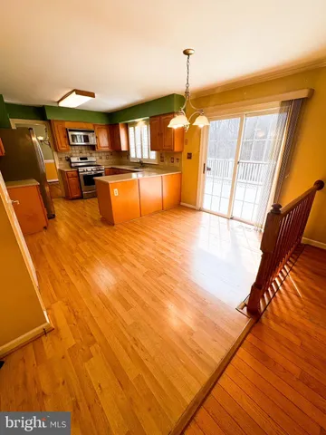 a view of a kitchen with stainless steel appliances wooden floor and a large window