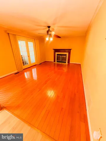 a view of empty room with window and wooden floor