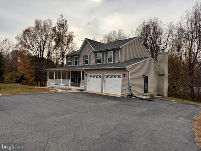 a front view of house with yard and trees in the background