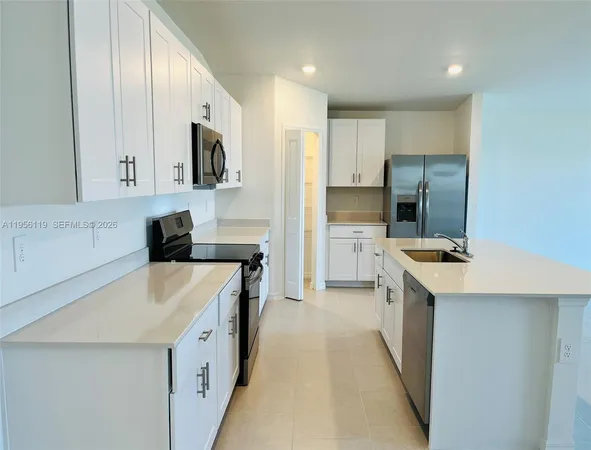 a kitchen with stainless steel appliances a sink stove and refrigerator
