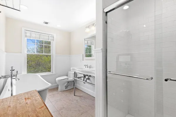 a bathroom with a bathtub shower sink and toilet
