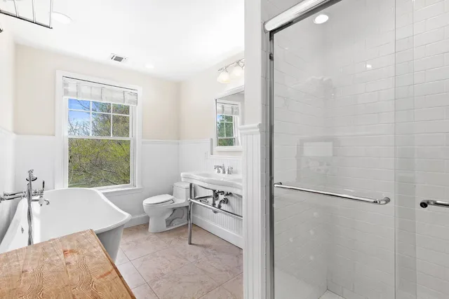 a bathroom with a bathtub shower sink and toilet