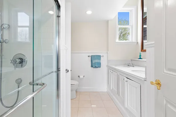 a bathroom with a sink a toilet and shower