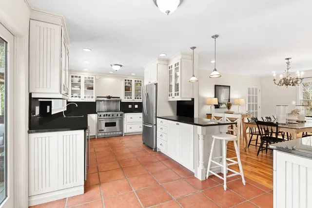 a kitchen with stainless steel appliances kitchen island granite countertop a refrigerator and cabinets