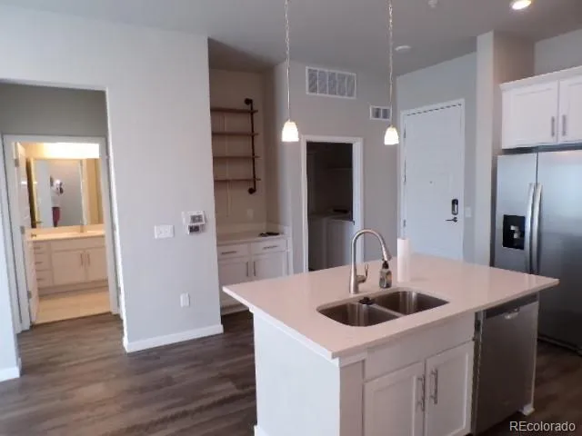 a kitchen with a sink a refrigerator and cabinets