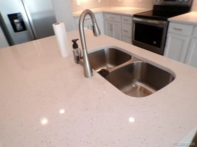 a view of kitchen with a sink and refrigerator