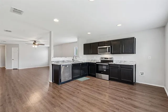 a large kitchen with a sink and a stove top oven