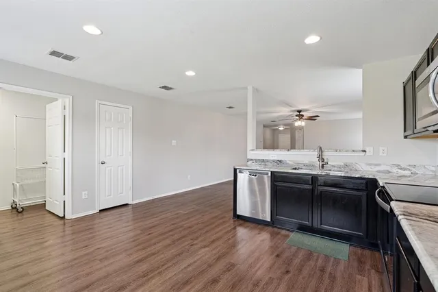 a kitchen with stainless steel appliances granite countertop a sink stove and refrigerator