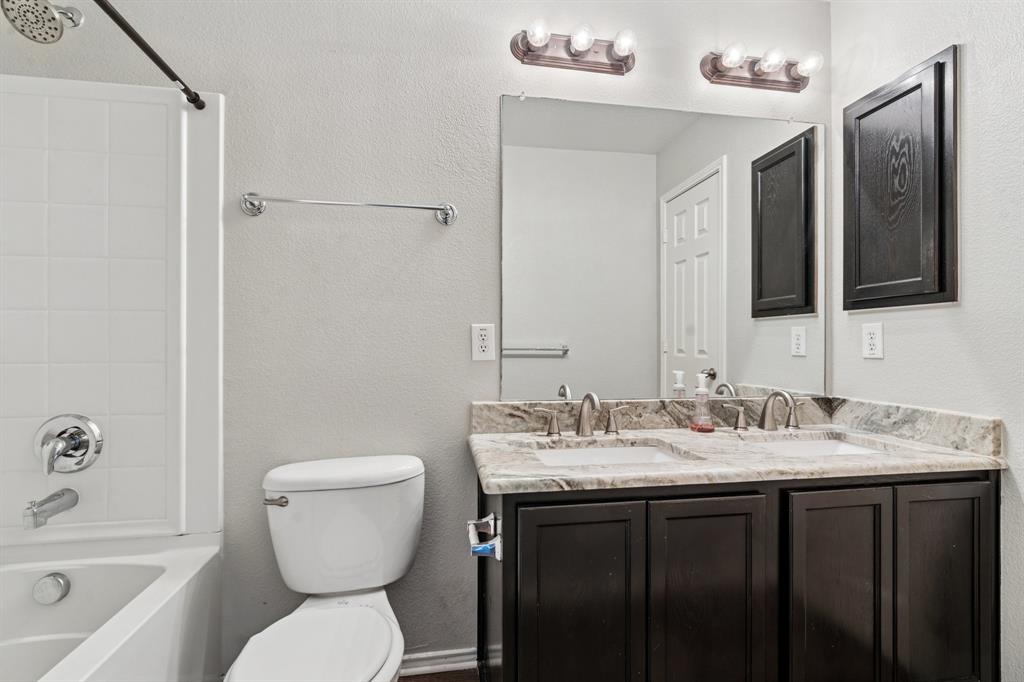 3005 Groveland Terrace Denton, TX 76210 - Photo 17 of 26 a bathroom with a toilet sink and mirror a bathtub