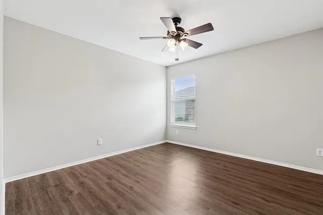 a view of a room with wooden floor and a ceiling fan