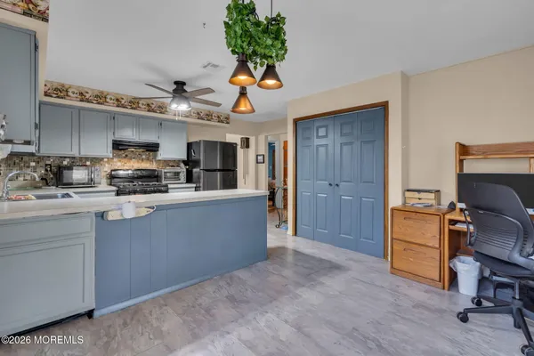 a kitchen with kitchen island a stove a sink a microwave a dining table and chairs