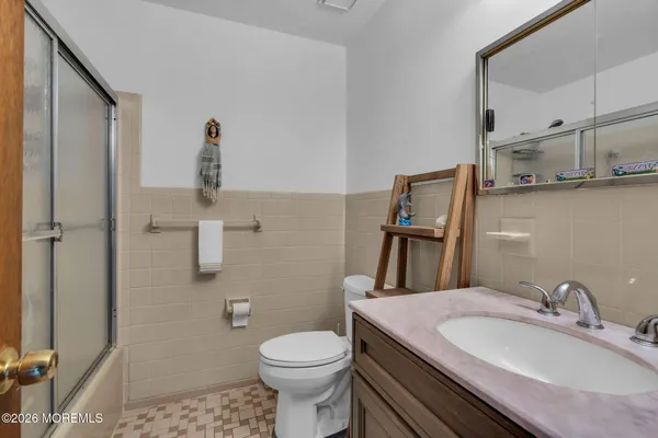 a bathroom with a granite countertop toilet sink and mirror