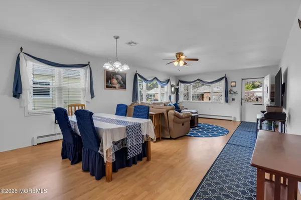 a living room with furniture a dining table and a chandelier