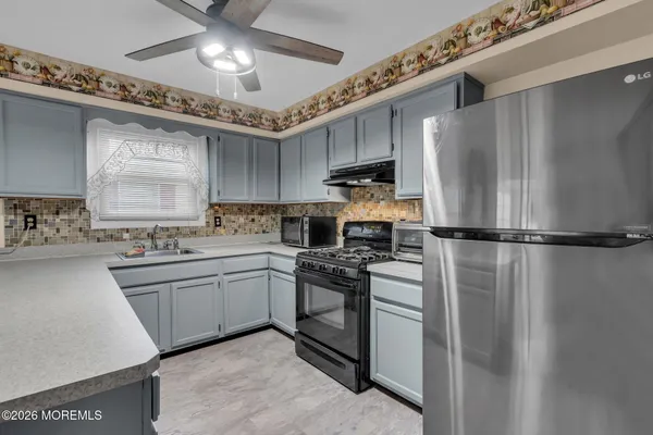a kitchen with kitchen island a sink stainless steel appliances and cabinets