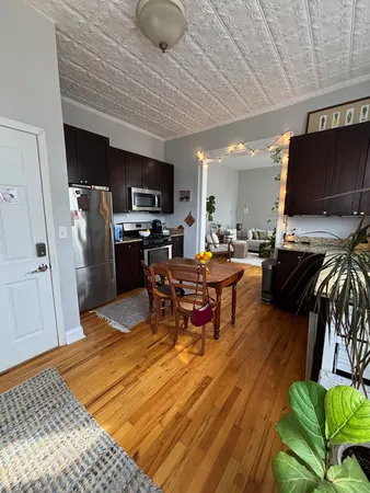 a living room with furniture a flat screen tv and kitchen view