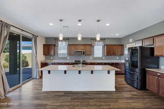 a view of kitchen with stainless steel appliances granite countertop a stove and a refrigerator