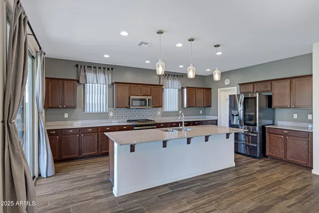 a large kitchen with stainless steel appliances and a stove top oven