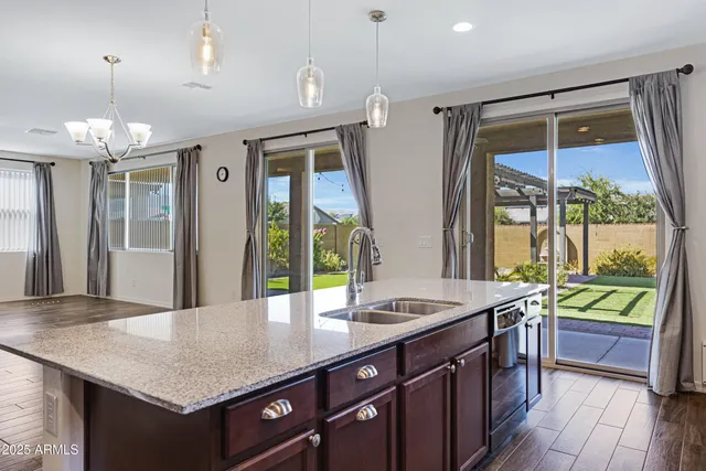 a bathroom with a granite countertop sink and a large mirror