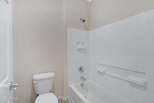 a white toilet sitting next to a bath tub
