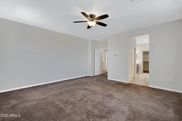 an empty room with closet and ceiling fan