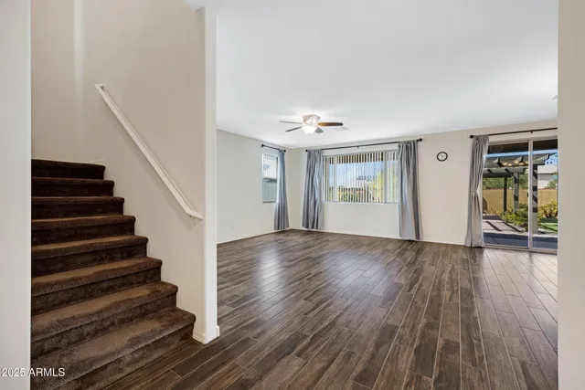 a view of an empty room with wooden floor and workspace