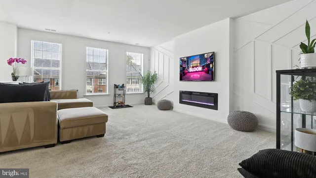 a living room with furniture a floor to ceiling window and potted plant