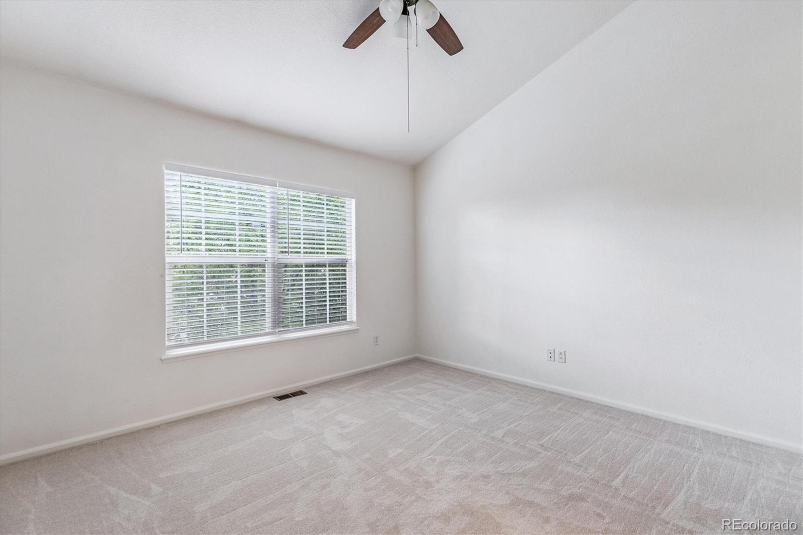 260 West Jamison Circle, Unit 13 Littleton, CO 80120 - Photo 14 of 24 an empty room with chandelier fan and windows