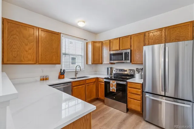 a kitchen with stainless steel appliances granite countertop a refrigerator stove top oven and sink