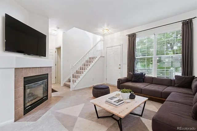 a living room with furniture a flat screen tv and a fireplace